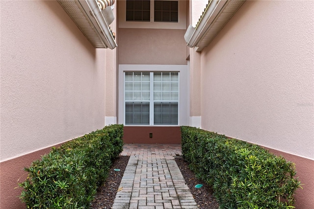 view of exterior entry with a patio area