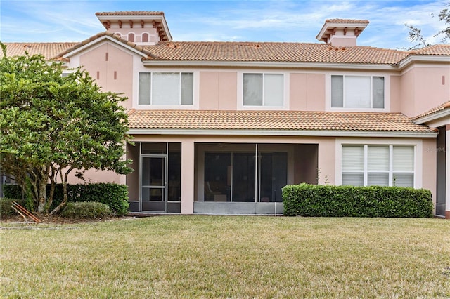 back of house featuring a sunroom and a lawn