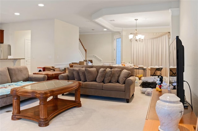 living room featuring a chandelier, ornamental molding, light carpet, and a tray ceiling