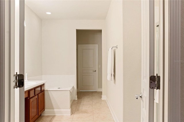 bathroom with a tub to relax in, tile patterned flooring, and vanity