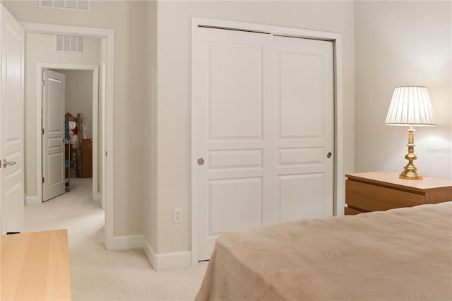 bedroom featuring light colored carpet and a closet