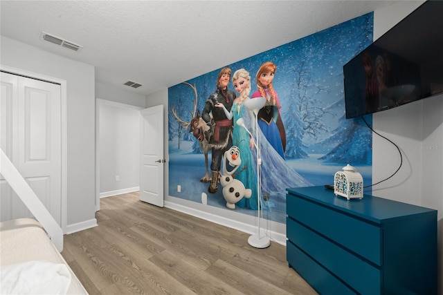 bedroom featuring hardwood / wood-style floors and a textured ceiling