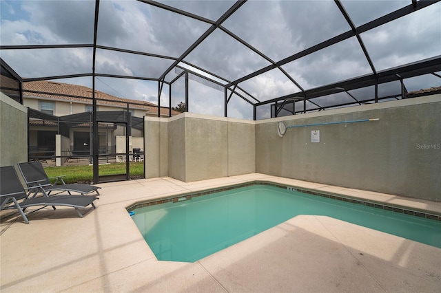 view of swimming pool with a patio area and glass enclosure