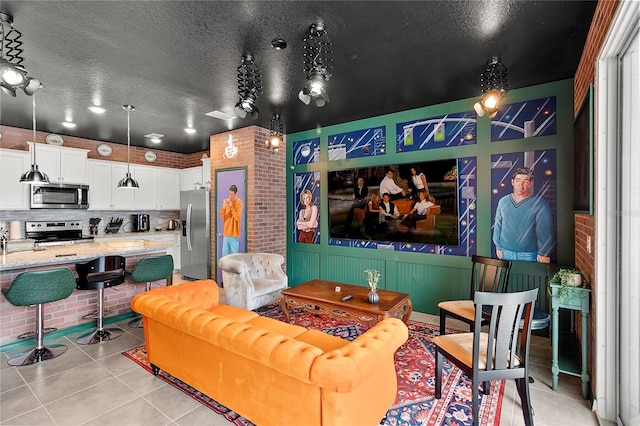 tiled cinema room with a textured ceiling, brick wall, and sink