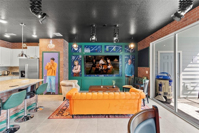 interior space with brick wall and a textured ceiling