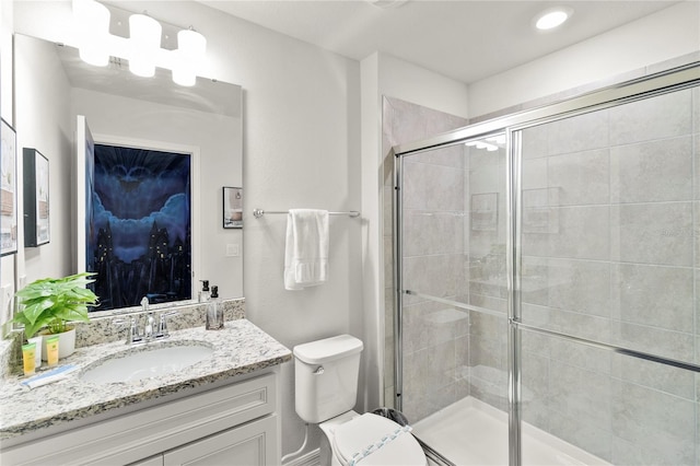 bathroom featuring toilet, large vanity, and walk in shower