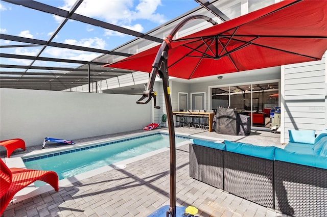 view of swimming pool with an outdoor living space, a patio, and a lanai