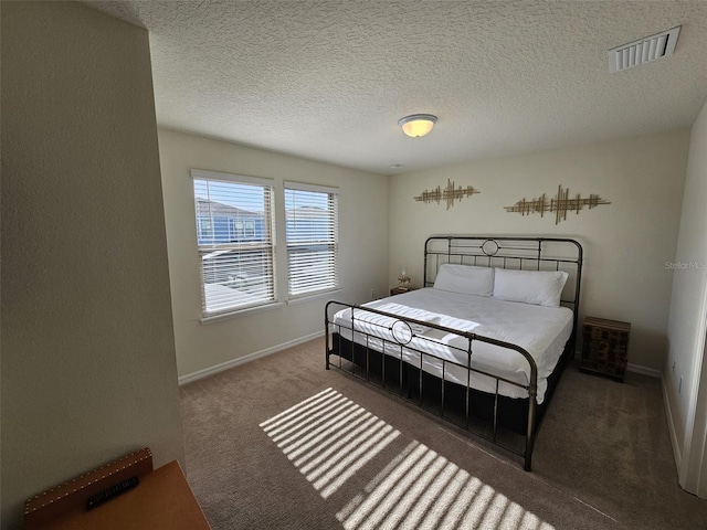 bedroom with carpet and a textured ceiling