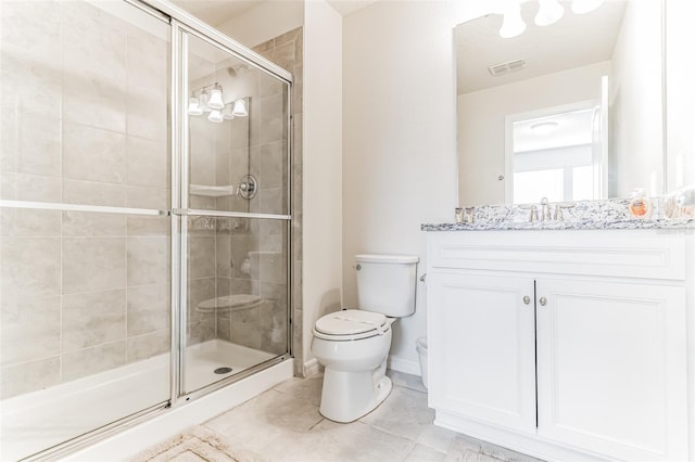 bathroom featuring tile patterned flooring, vanity, toilet, and a shower with shower door