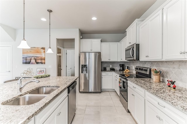 kitchen with tasteful backsplash, white cabinets, hanging light fixtures, and appliances with stainless steel finishes