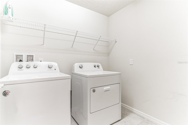 laundry room with a textured ceiling and independent washer and dryer