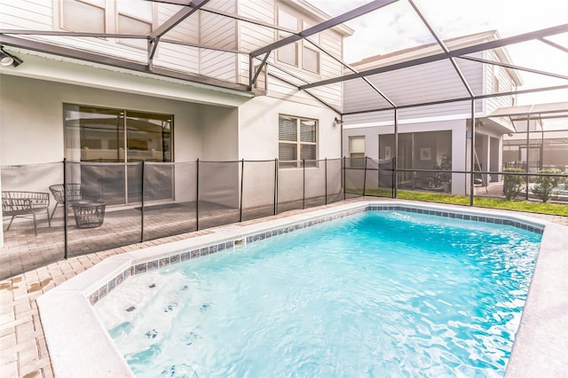 view of swimming pool featuring a patio and a lanai