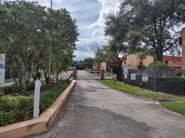 view of road featuring curbs, a gated entry, and a gate