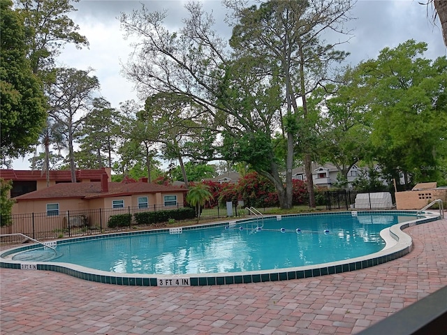 pool featuring a patio area and fence