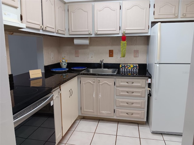 kitchen with black range with electric cooktop, white cabinetry, a sink, and freestanding refrigerator