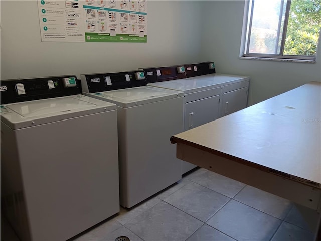 common laundry area with light tile patterned floors and washing machine and clothes dryer