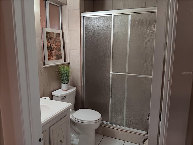 full bathroom with a stall shower, tile walls, vanity, and toilet