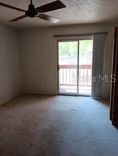 carpeted spare room featuring a ceiling fan and a textured ceiling