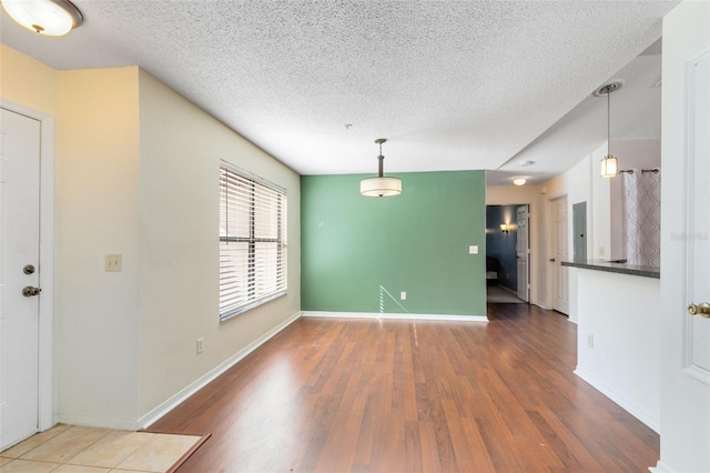 unfurnished room featuring a textured ceiling and dark hardwood / wood-style flooring