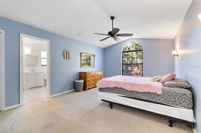 bedroom featuring lofted ceiling, ensuite bath, ceiling fan, and light colored carpet