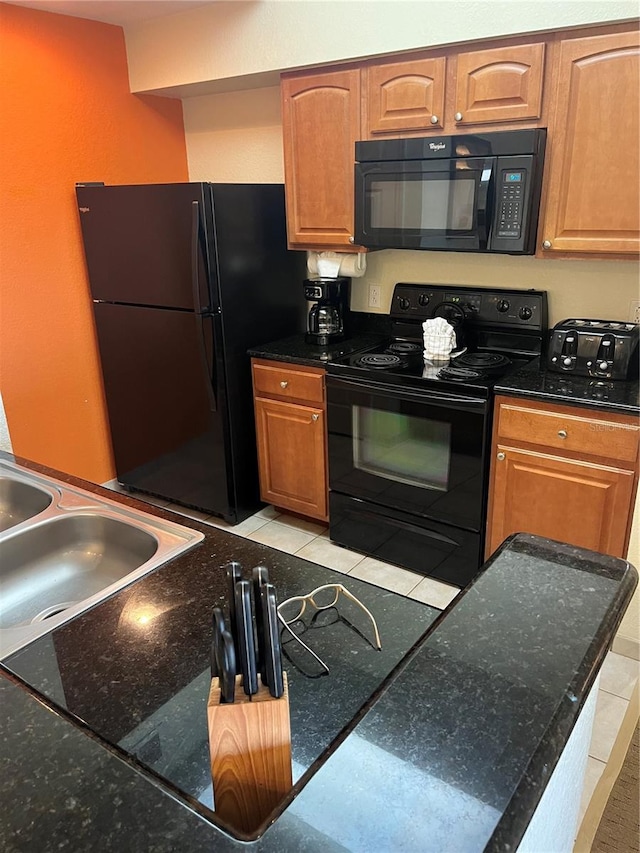 kitchen with light tile floors, black appliances, and sink