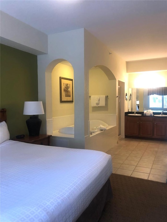 bedroom with light tile floors and sink