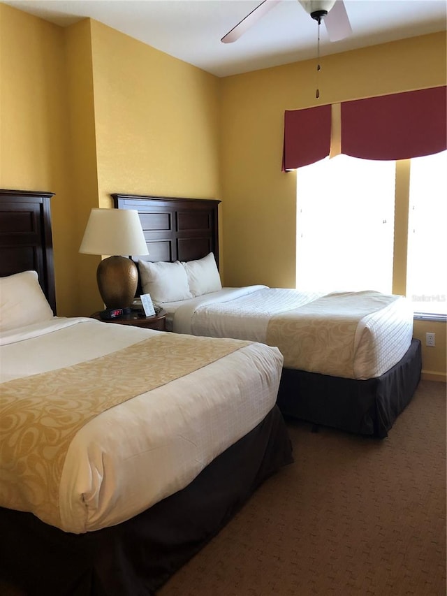 bedroom featuring ceiling fan and dark carpet