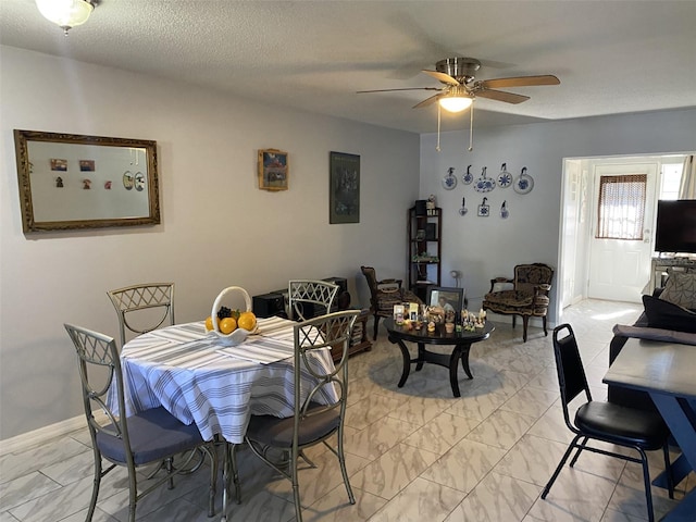 dining area with ceiling fan and a textured ceiling