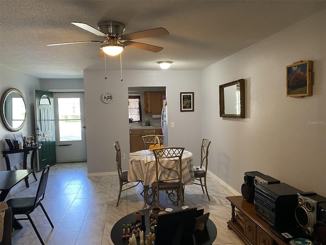 dining space featuring ceiling fan and a textured ceiling