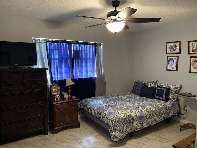 bedroom featuring ceiling fan and a textured ceiling