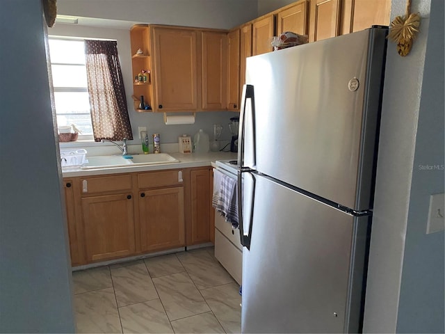 kitchen with light tile patterned floors, sink, stainless steel fridge, and white range with electric cooktop