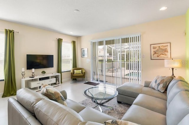 living room featuring plenty of natural light, recessed lighting, and baseboards