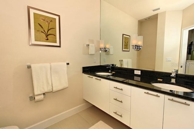 bathroom featuring double vanity, baseboards, visible vents, and a sink