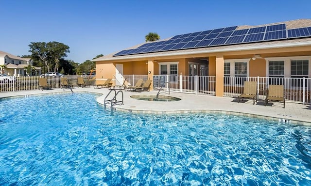 community pool with a patio, a community hot tub, a ceiling fan, and fence