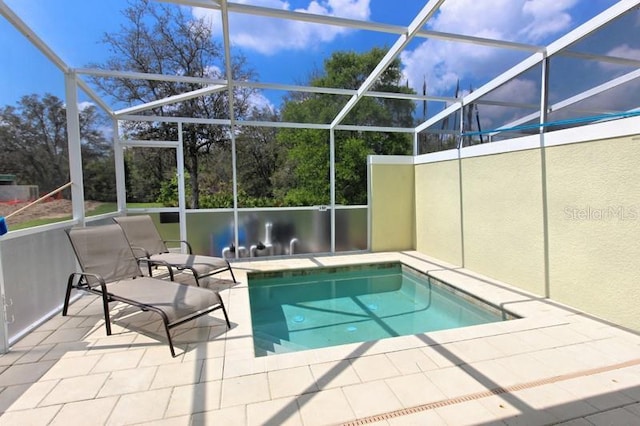 view of swimming pool featuring glass enclosure and a patio area