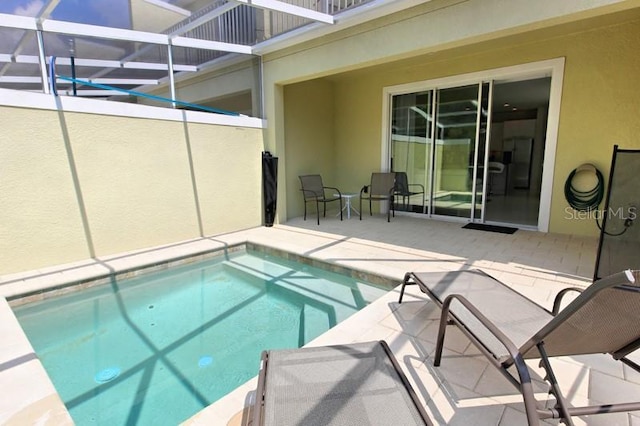 view of swimming pool with glass enclosure and a patio area