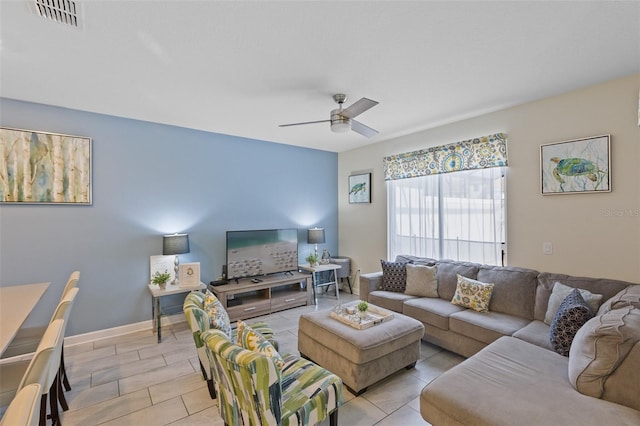 living room featuring light tile floors and ceiling fan