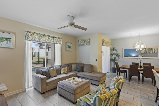 tiled living room with ceiling fan with notable chandelier