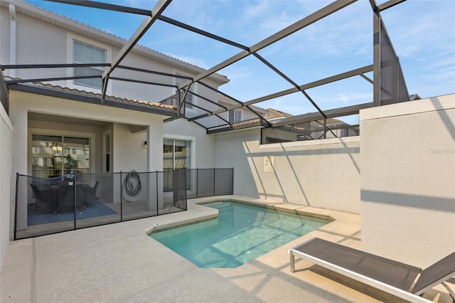 view of swimming pool with a patio area and glass enclosure