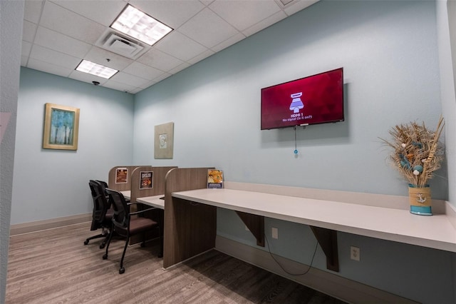 office space with a drop ceiling and light hardwood / wood-style flooring