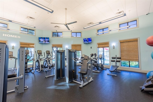 workout area with ceiling fan and a high ceiling