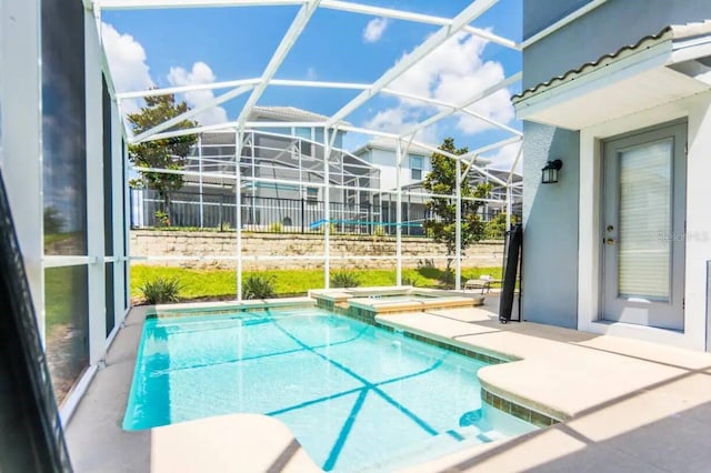 view of pool with a patio, an in ground hot tub, and glass enclosure