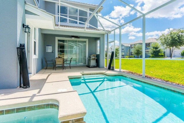 view of pool featuring a lanai, ceiling fan, a lawn, and a patio