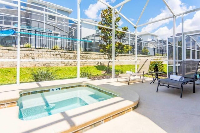 view of pool featuring an in ground hot tub, glass enclosure, and a patio