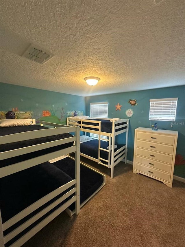 bedroom featuring dark carpet and a textured ceiling