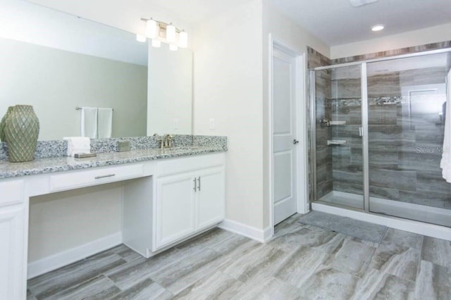 bathroom featuring vanity and a shower with door