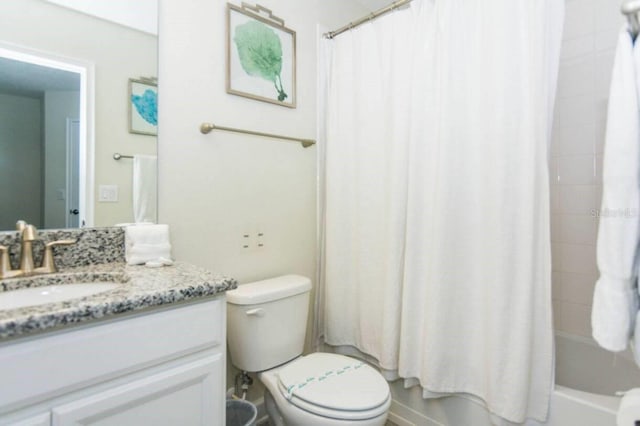 full bathroom featuring toilet, vanity with extensive cabinet space, and shower / tub combo