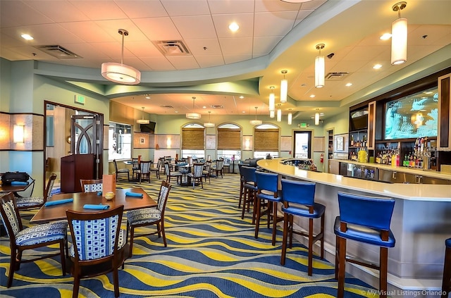 bar with carpet, pendant lighting, and a paneled ceiling