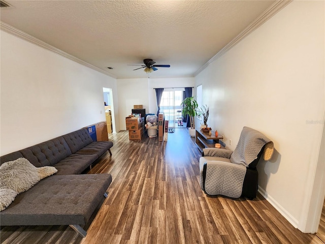 living room featuring baseboards, ceiling fan, dark wood-style flooring, crown molding, and a textured ceiling