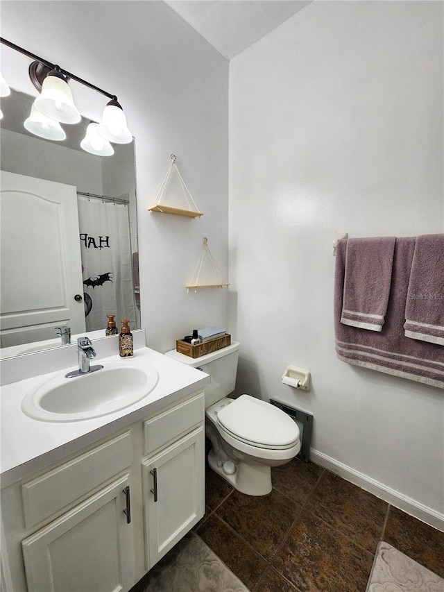 bathroom with toilet, curtained shower, baseboards, and vanity